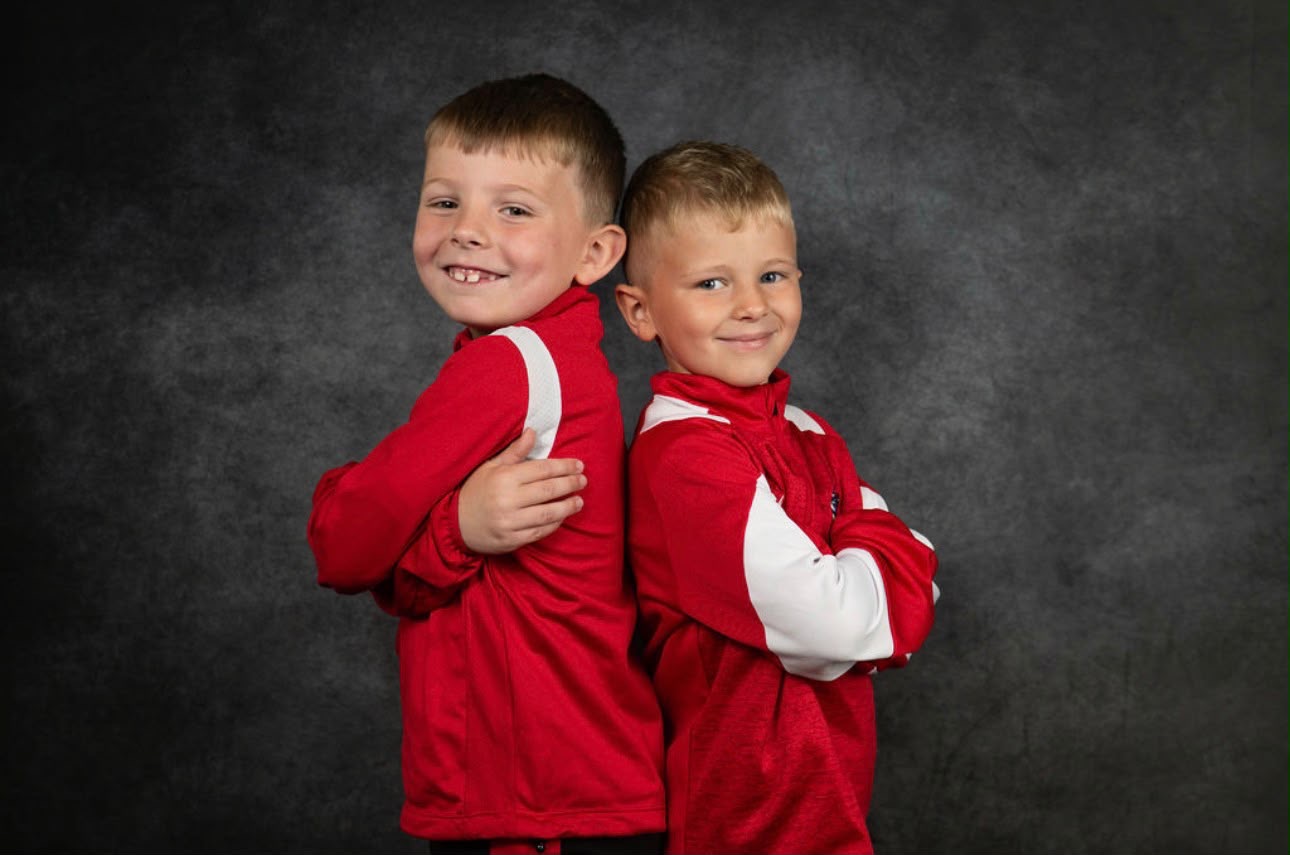 Two young players back to back in club tracksuits