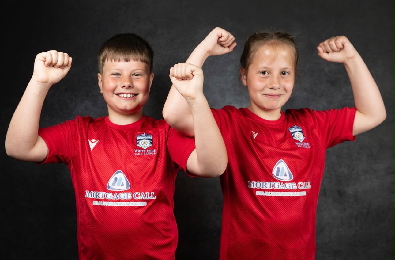 Two smiling players flexing in red White Rose shirts